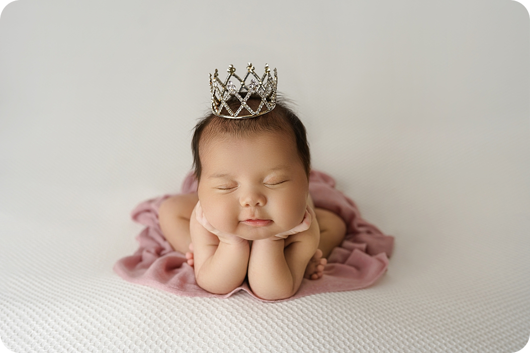 baby sleeps in froggy pose during newborn photos in Utah studio