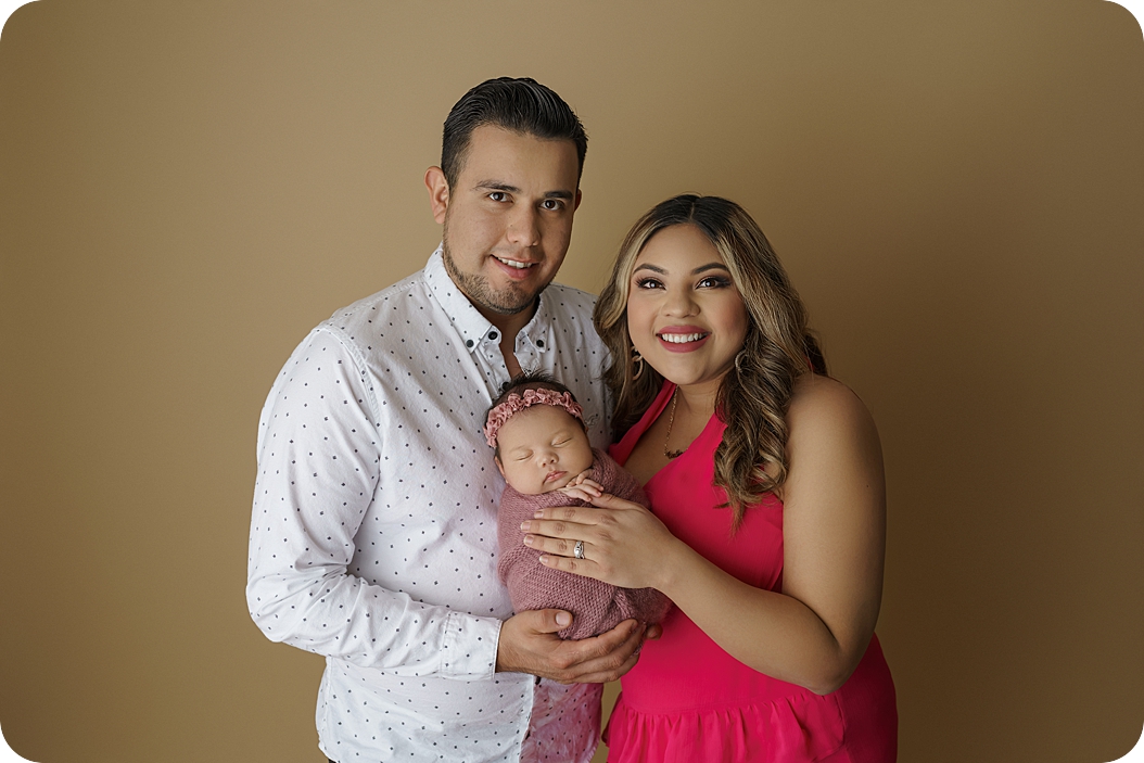 parents hold new baby girl during newborn photos in Utah studio