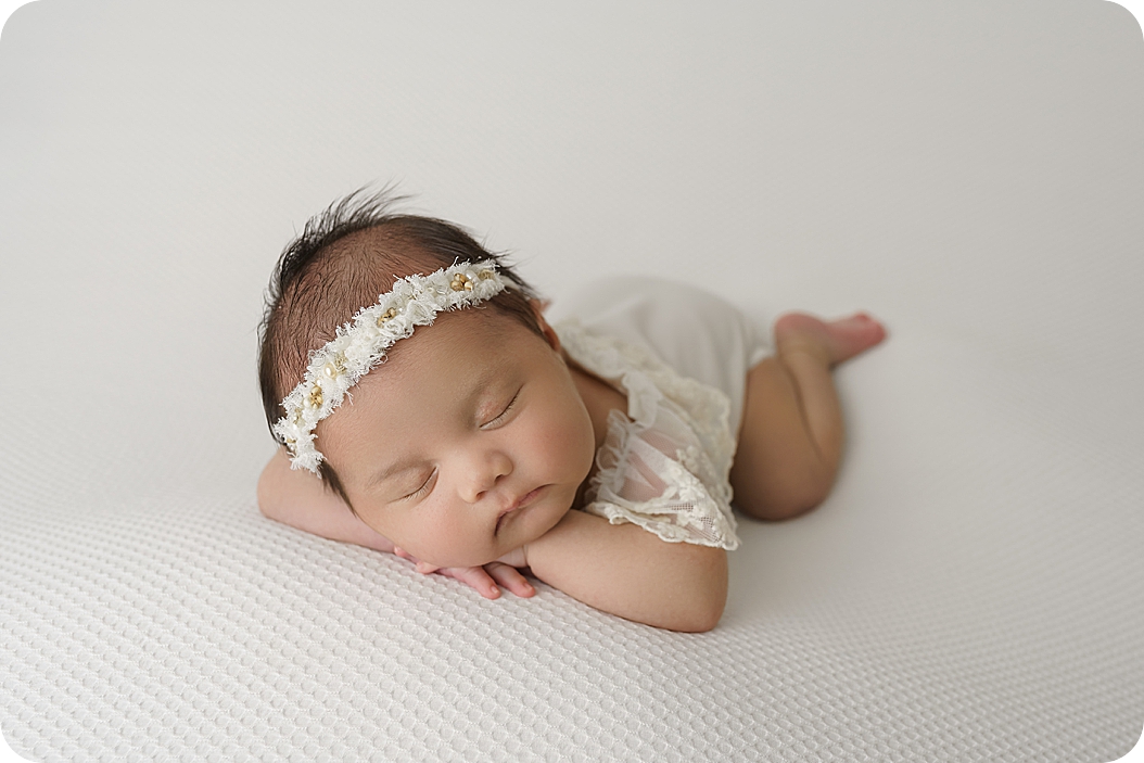 baby sleeps on white setup during newborn photos in Utah