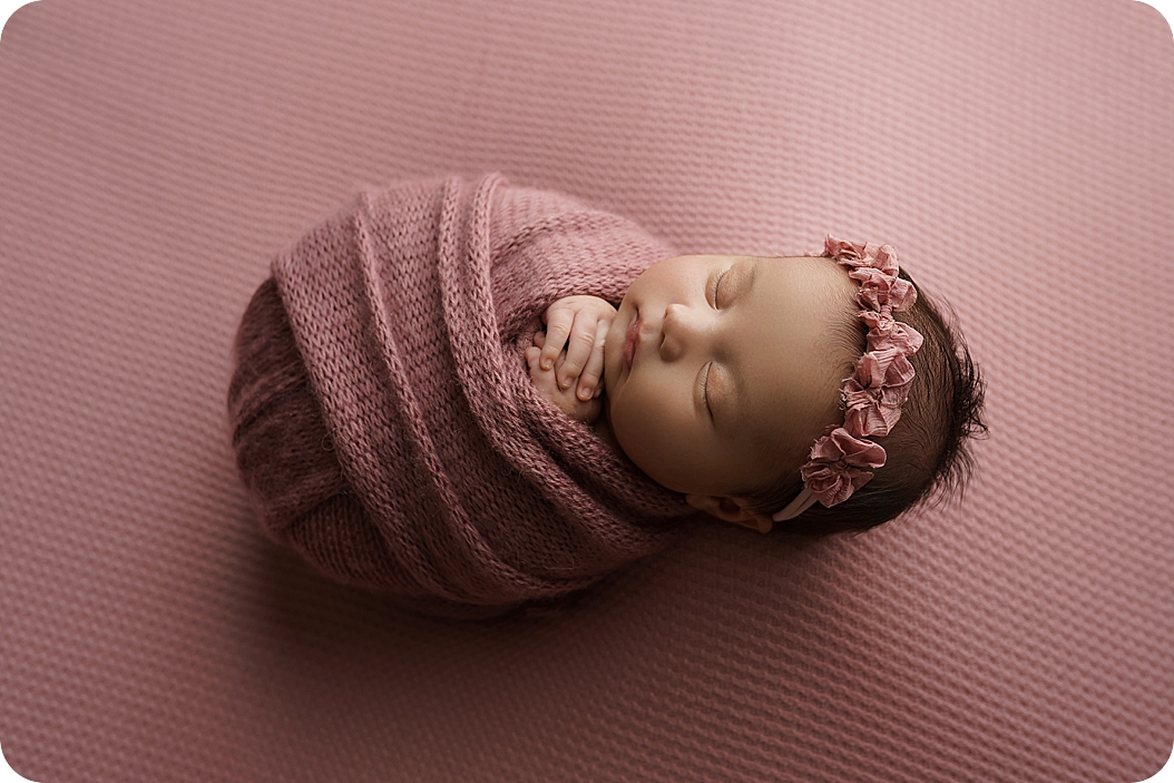 baby in pink sleeps during newborn session