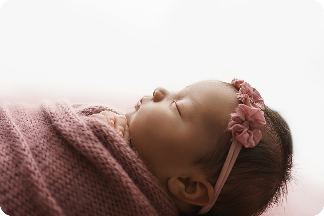 baby girl in mauve wrap sleeps during UT newborn photos