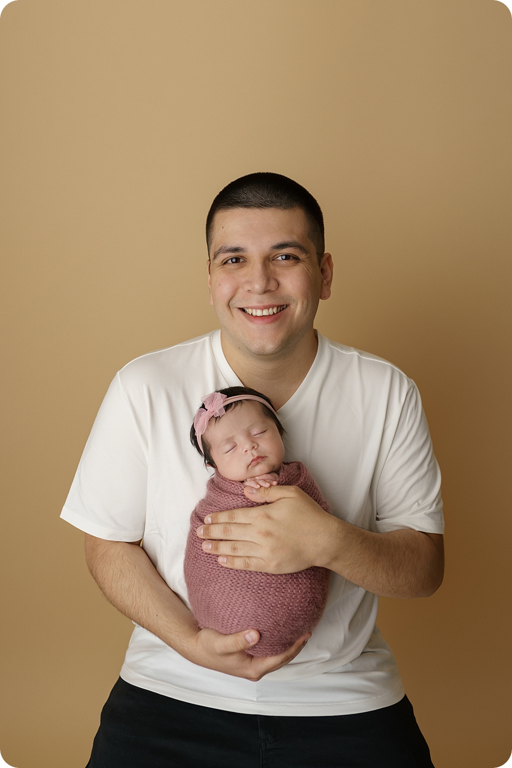 dad holds baby girl during newborn photos in Holladay UT