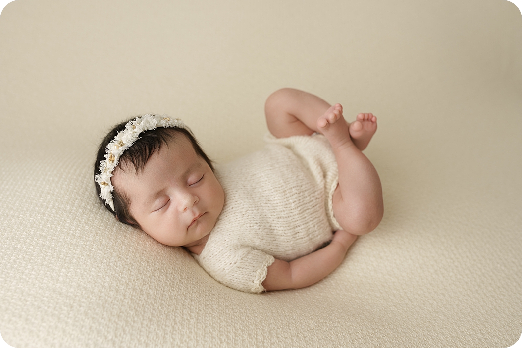 baby girl lays on back during newborn photos 