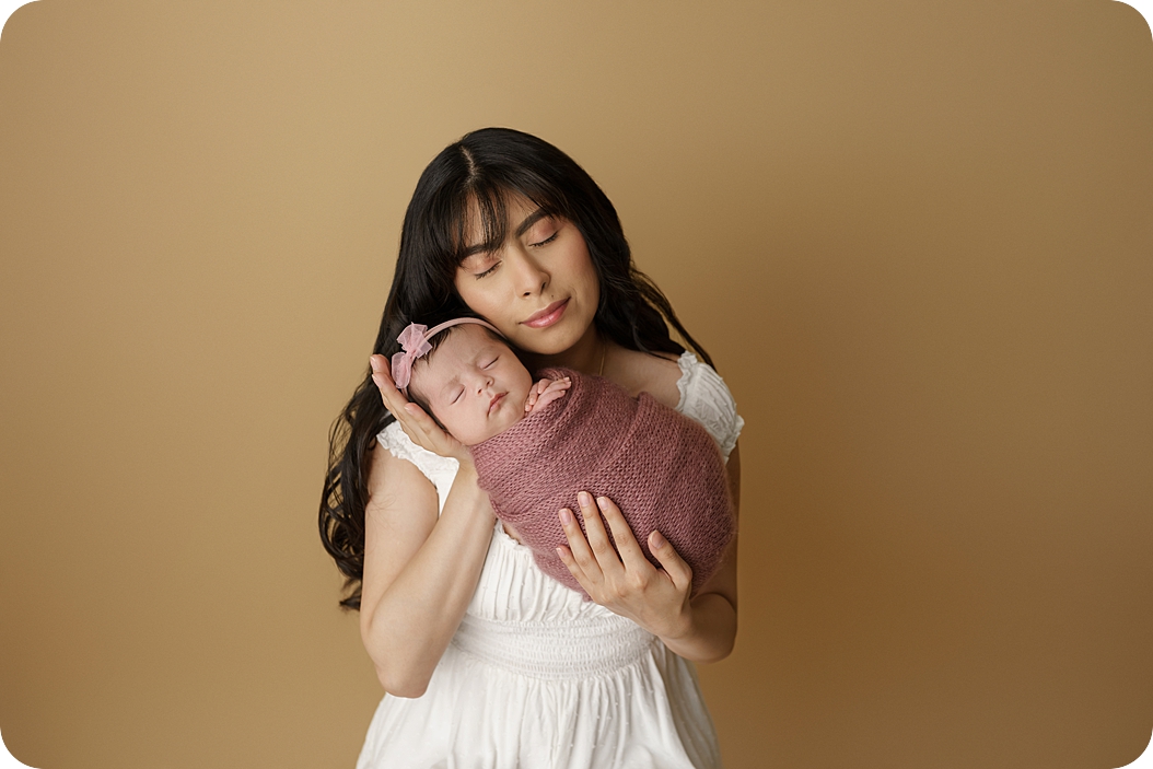 mom and daughter snuggle during studio newborn portraits in Utah