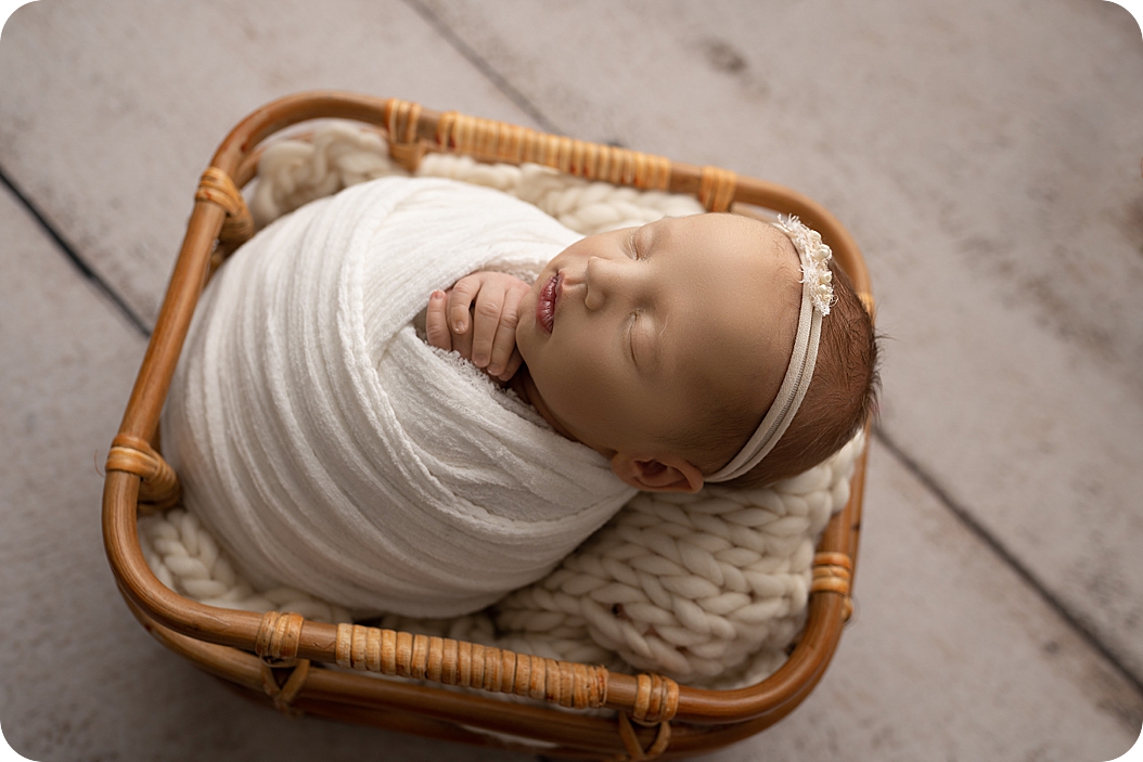 baby sleeps in basket during newborn photos