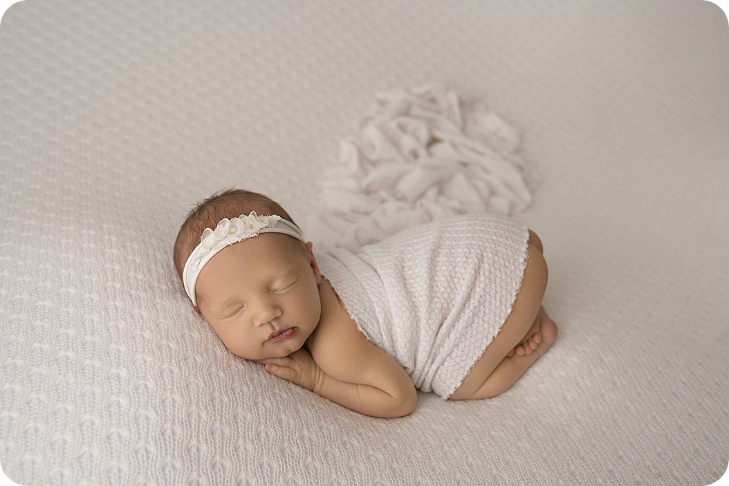 baby girl lays in white wrap during Studio Newborn Session in Utah 