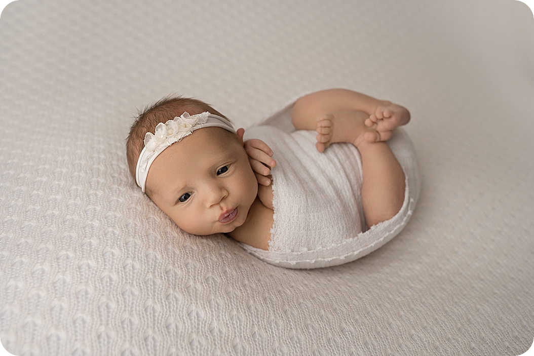 girl lays with eyes open during Utah newborn photos