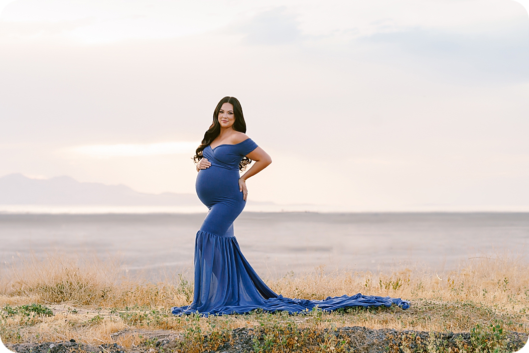 woman poses on hill during Lakeside Maternity Portraits