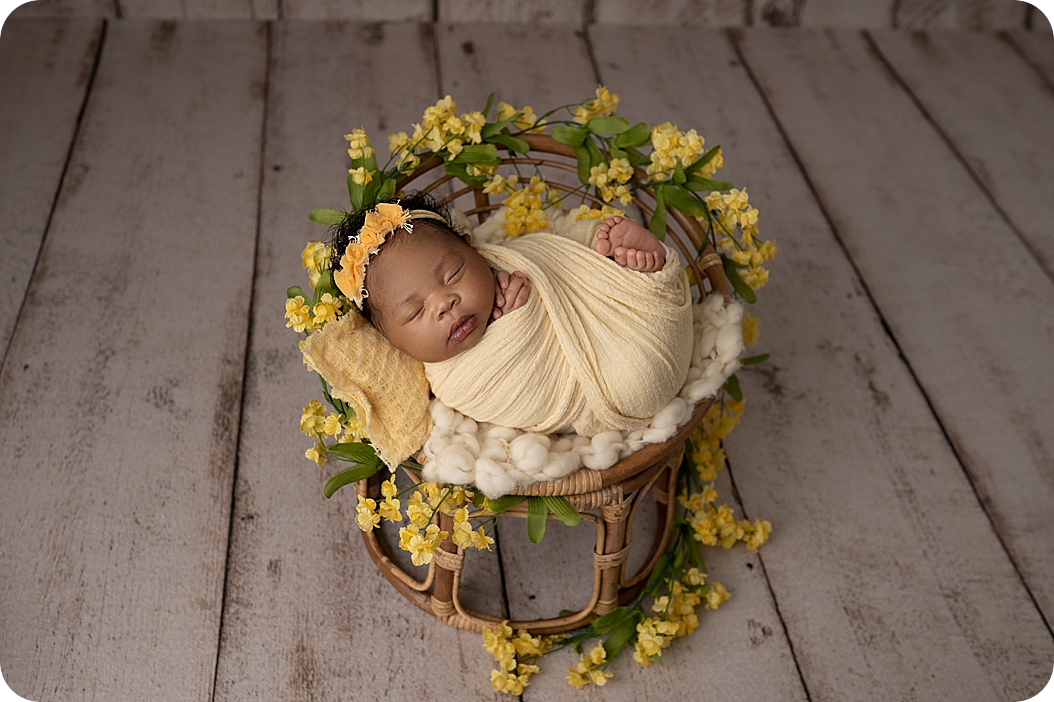 baby sleeps in yellow wrap with floral accents