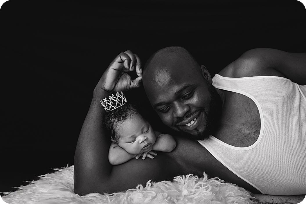 dad lays with baby on arm during studio session