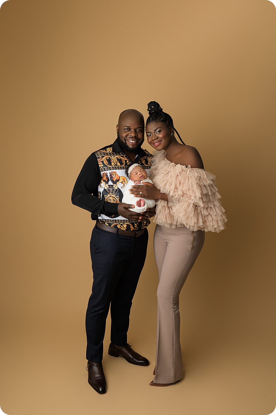 parents hold baby girl during stylish newborn portraits