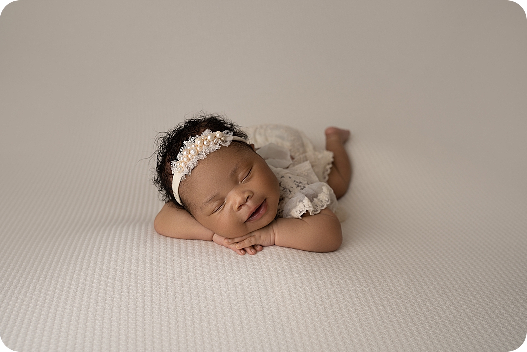 baby girl smiles in sleep during UT newborn photos