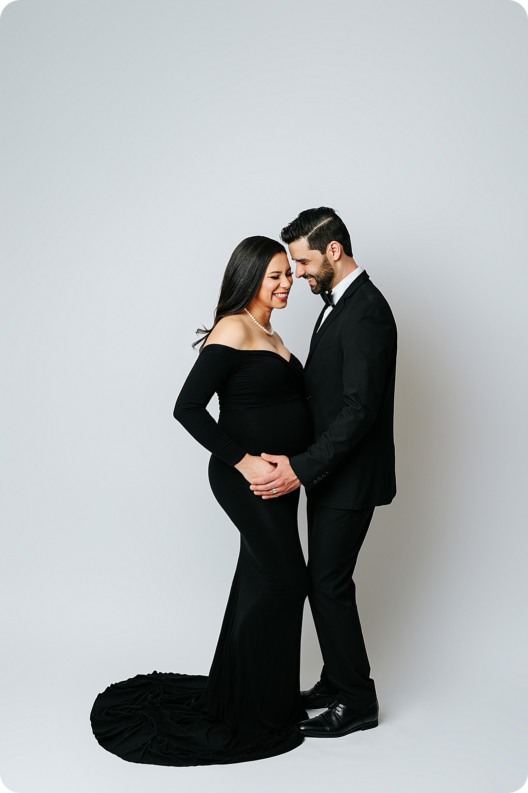 husband and wife pose in studio during black-tie maternity photos