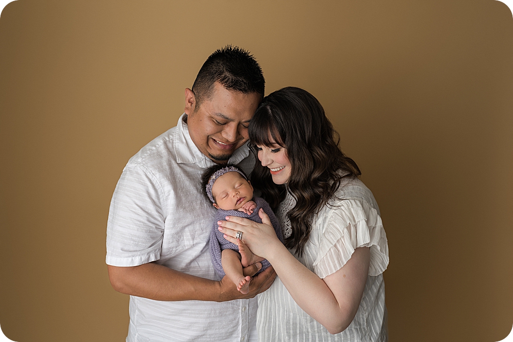 parents snuggle with daughter during Utah Newborn Session