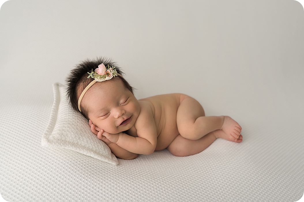 baby girl lays on pillow during Utah Newborn Session