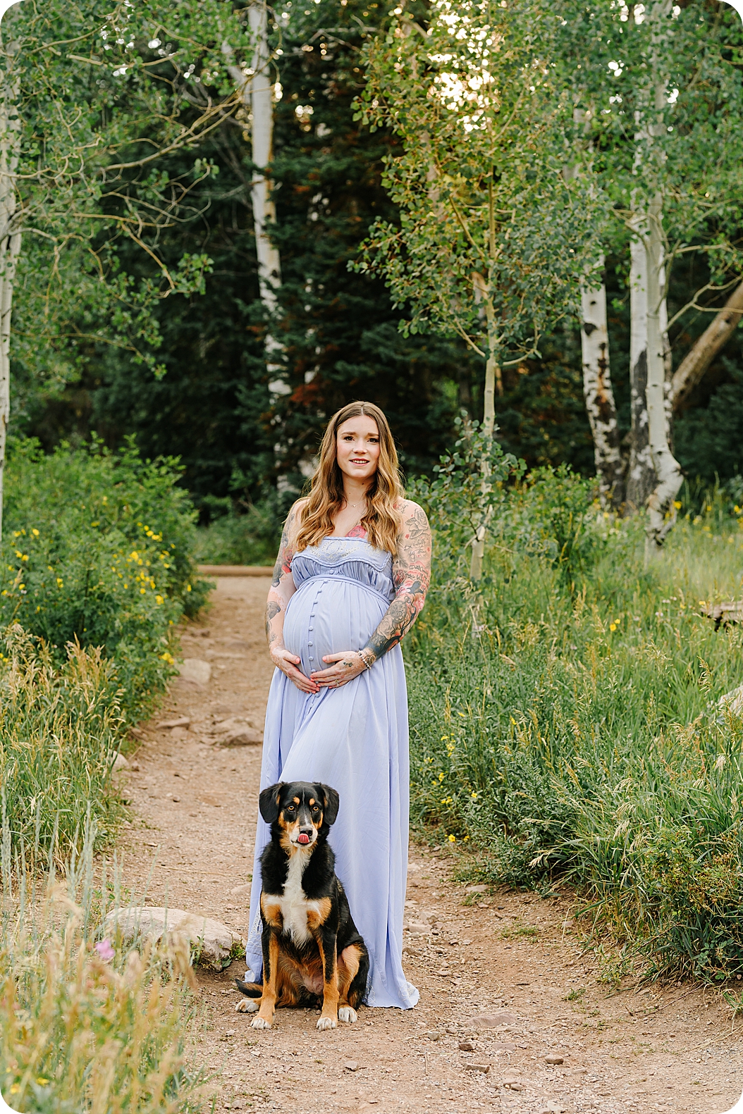 expecting mom stands by dog during canyon maternity portraits