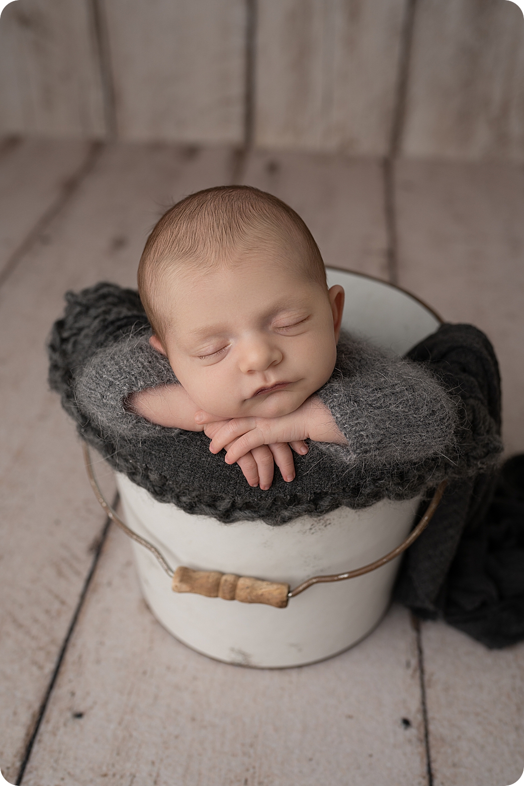 baby lays in bucket during neutral toned newborn session