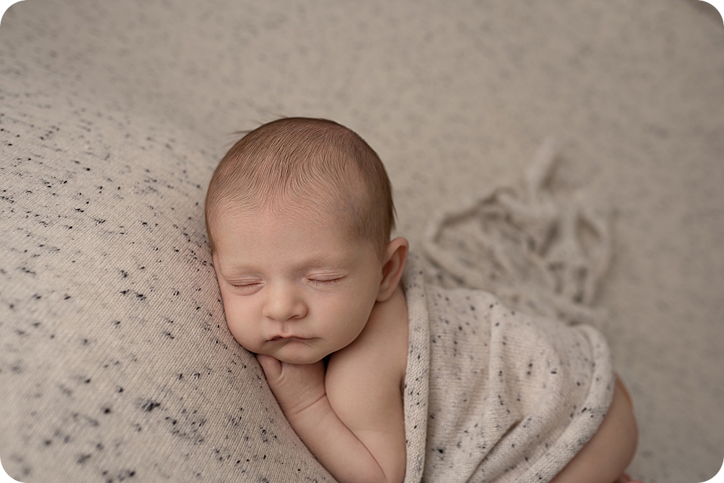 baby boy lays on stomach during newborn session 