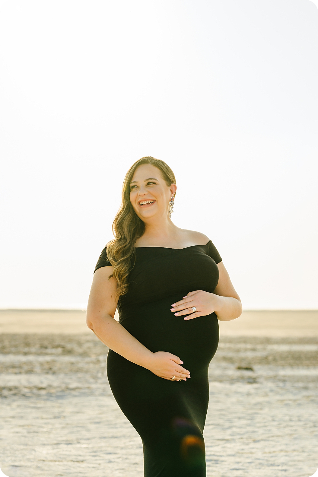 mom holds belly during classic maternity portraits in Utah