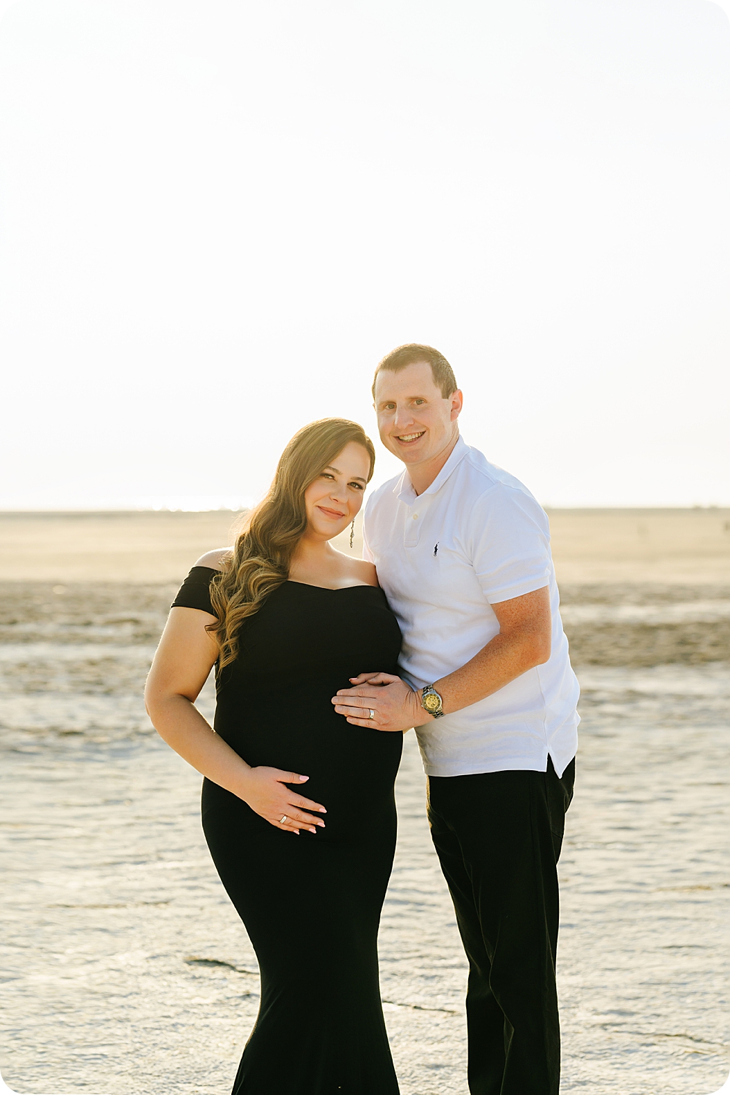 new parents pose in lake bed during Utah maternity photos