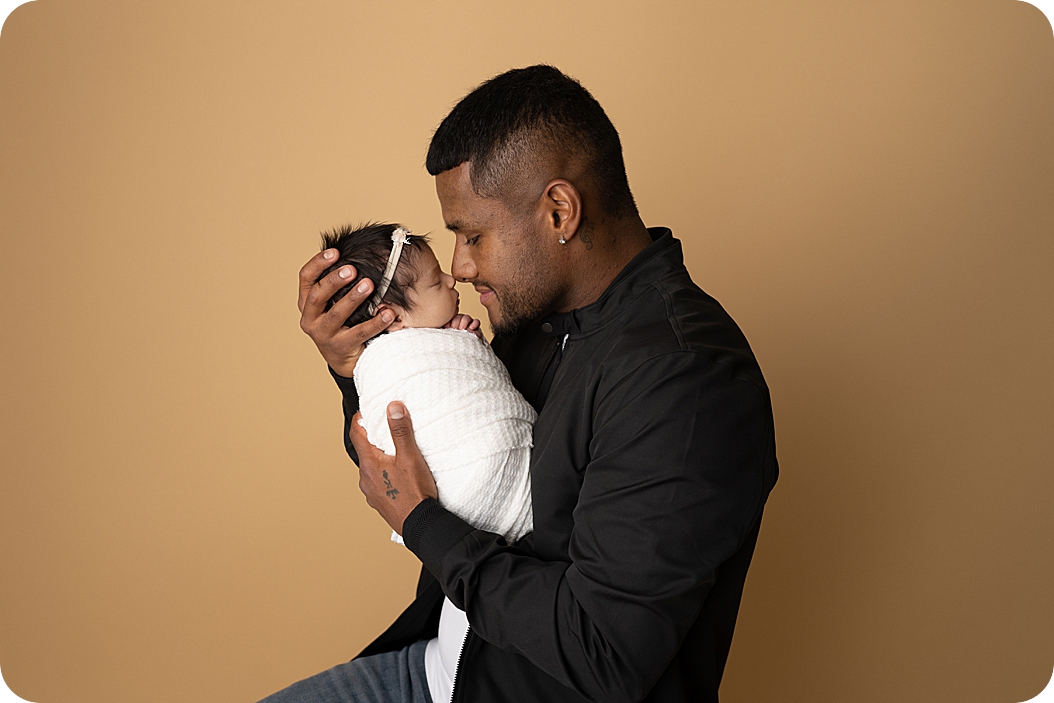 dad nuzzles noses with his daughter during Utah newborn portraits