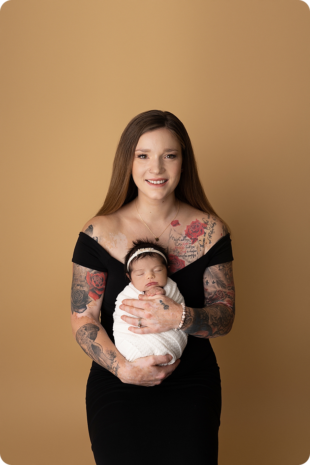 mom holds baby girl during studio Utah newborn portraits