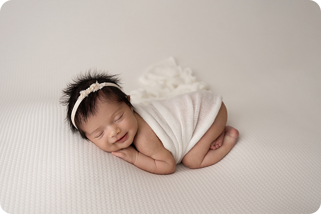 baby sleeps in white wrap during fall inspired newborn portraits 