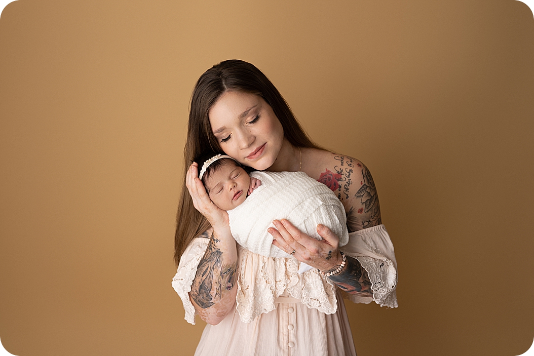 mom holds daughter during Utah newborn portraits