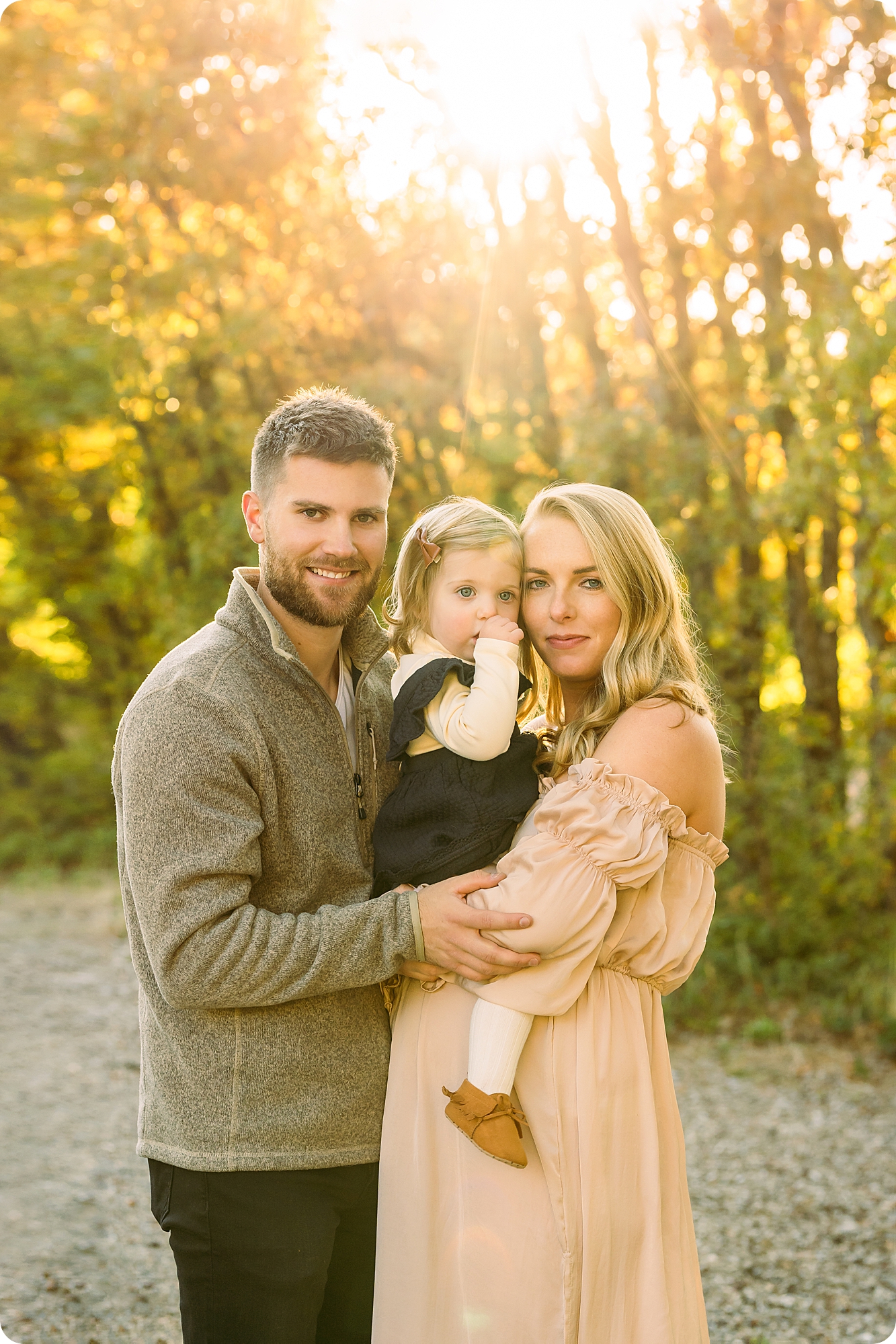 family holds daughter during maternity session in Utah 